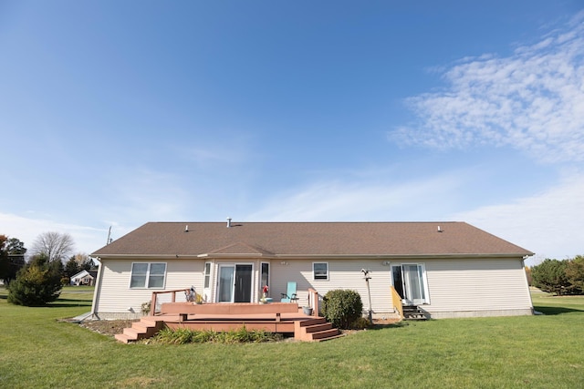 back of property featuring a wooden deck, entry steps, and a lawn