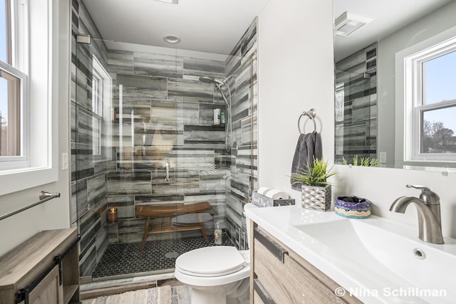 full bathroom featuring toilet, a stall shower, and vanity