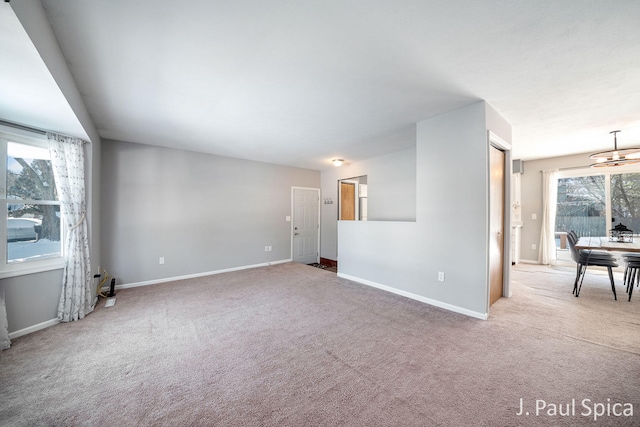 unfurnished room featuring carpet and baseboards