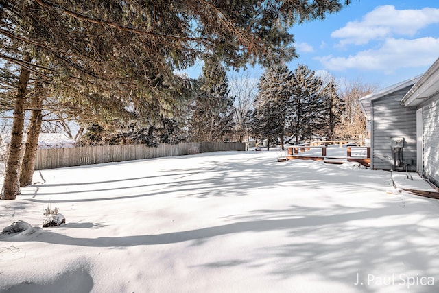 yard layered in snow featuring fence