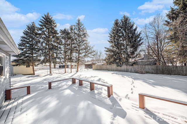 yard covered in snow featuring fence