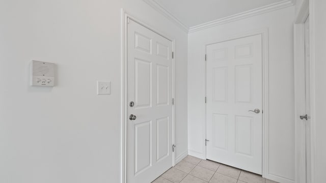 interior space with ornamental molding and light tile patterned flooring