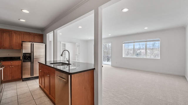 kitchen featuring crown molding, stainless steel appliances, brown cabinetry, a kitchen island with sink, and a sink