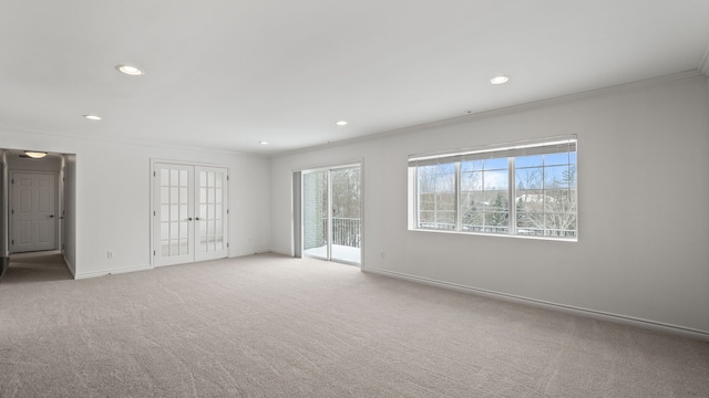 spare room with light carpet, recessed lighting, baseboards, and crown molding