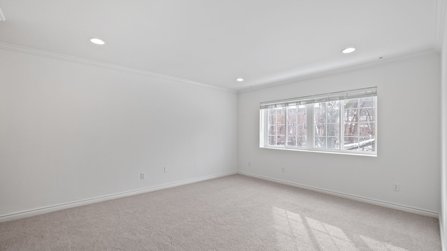 spare room featuring light carpet, baseboards, ornamental molding, and recessed lighting