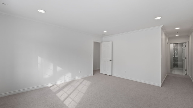 spare room with ornamental molding, recessed lighting, light colored carpet, and baseboards