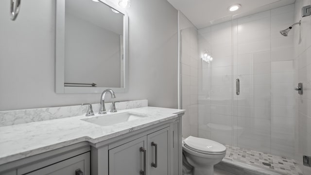 bathroom featuring a stall shower, vanity, and toilet