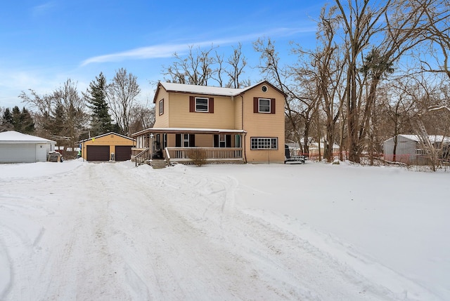 view of front of property featuring a garage, covered porch, and an outdoor structure