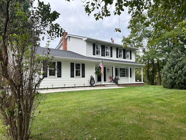 view of front of house with a front lawn, covered porch, and a chimney