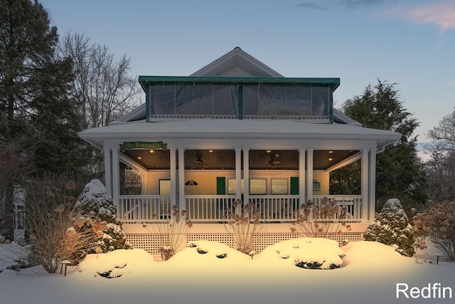 back of property at dusk with a porch