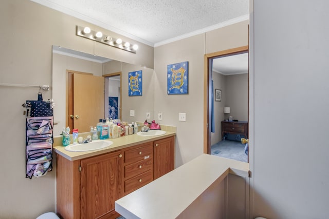 bathroom featuring a textured ceiling, ornamental molding, and a sink