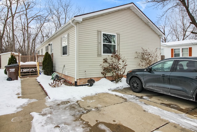 view of snow covered exterior featuring a wooden deck