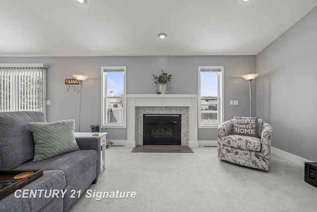 living area featuring light colored carpet, a tiled fireplace, recessed lighting, and baseboards