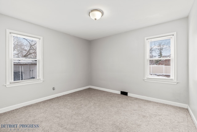 spare room featuring carpet and baseboards