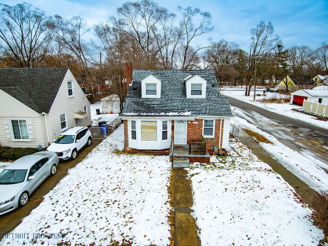 new england style home with brick siding, roof with shingles, and a residential view