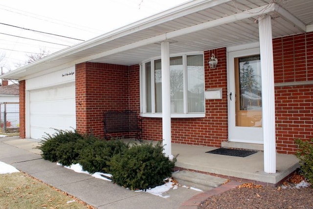 doorway to property featuring brick siding and an attached garage