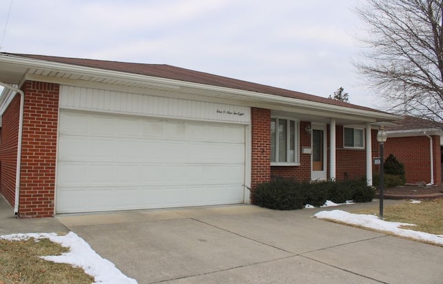 single story home featuring a garage, driveway, and brick siding