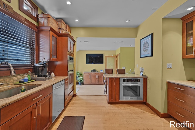 kitchen featuring glass insert cabinets, decorative backsplash, a sink, and dishwasher