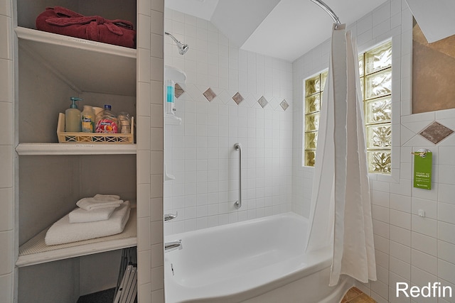 full bathroom with tile walls and shower / bath combination with curtain