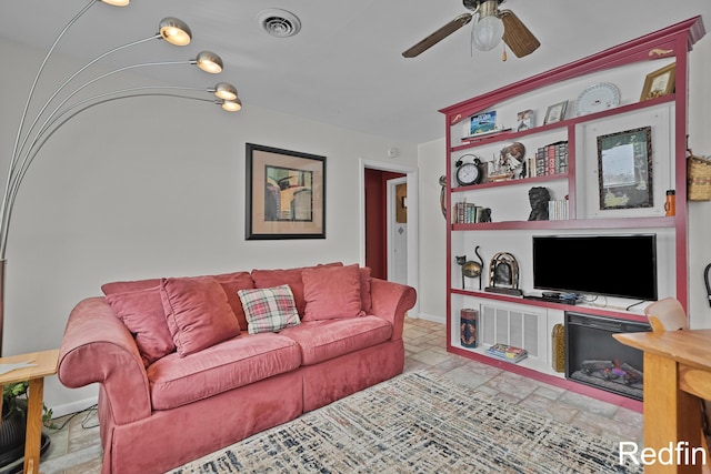 living area with a ceiling fan, visible vents, baseboards, and stone finish flooring