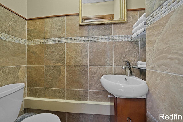 half bath with vanity, toilet, and tile walls