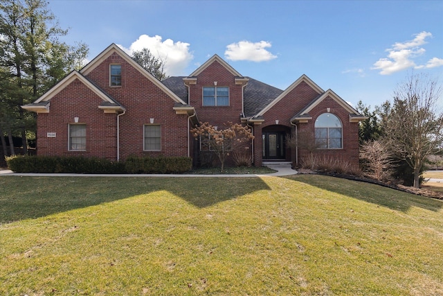 traditional-style house featuring brick siding and a front lawn