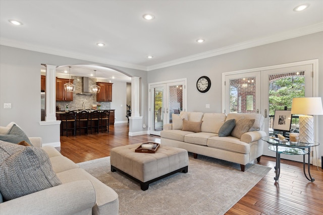 living area featuring french doors, wood finished floors, and crown molding