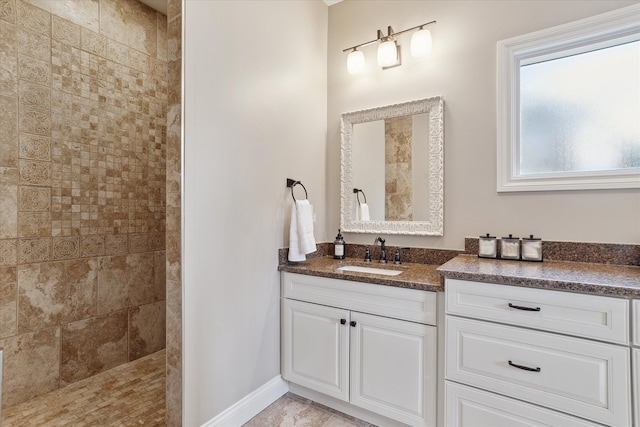 full bathroom featuring vanity, baseboards, and walk in shower