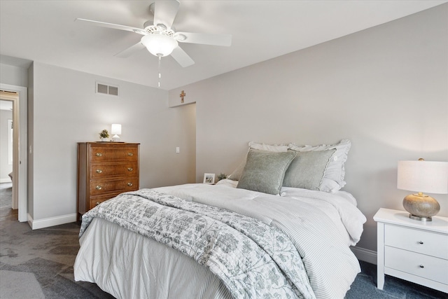 bedroom with a ceiling fan, baseboards, visible vents, and dark carpet