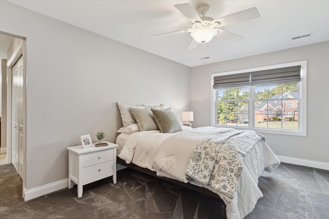 bedroom featuring baseboards, visible vents, dark colored carpet, and ceiling fan