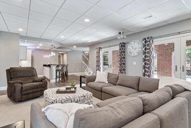 living area featuring visible vents, baseboards, recessed lighting, french doors, and wood finished floors