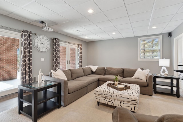 living room with a drop ceiling, french doors, and recessed lighting