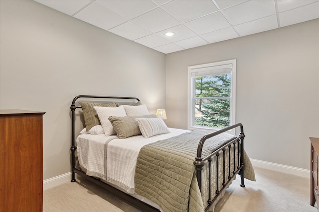 bedroom with a paneled ceiling, baseboards, and carpet floors