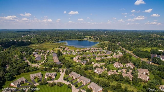 drone / aerial view with a residential view, a forest view, and a water view