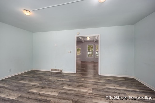 spare room with baseboards, visible vents, dark wood-type flooring, and attic access