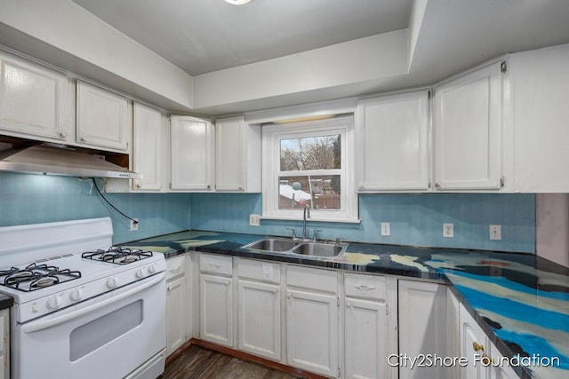 kitchen featuring a sink, white gas range, under cabinet range hood, dark countertops, and white cabinets