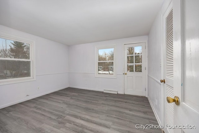 unfurnished room with baseboards and dark wood-type flooring