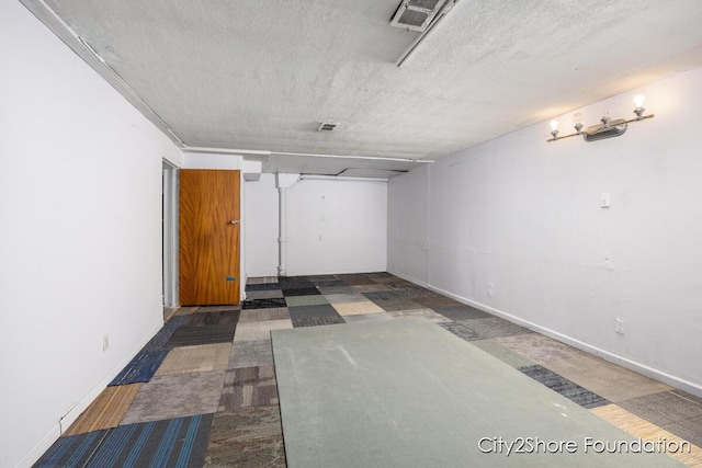 interior space with visible vents, baseboards, and a textured ceiling