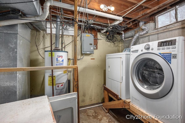 washroom with laundry area, washing machine and clothes dryer, electric panel, and gas water heater