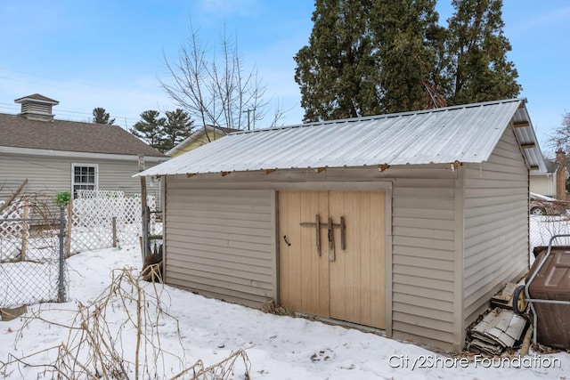 snow covered structure featuring fence