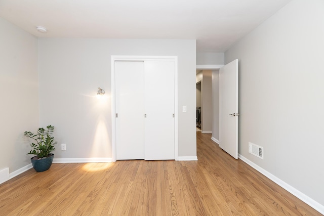 unfurnished bedroom featuring light wood-type flooring, visible vents, and baseboards