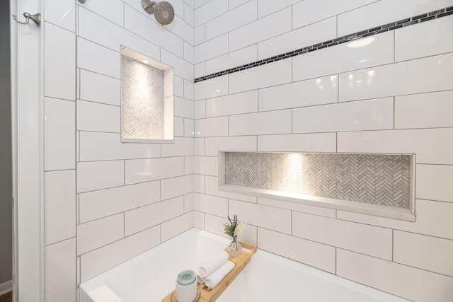 bathroom with a garden tub and tiled shower