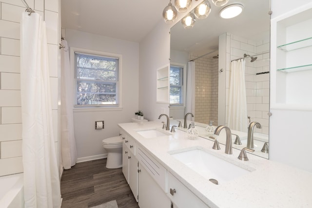 full bathroom featuring a sink, double vanity, wood finished floors, and toilet