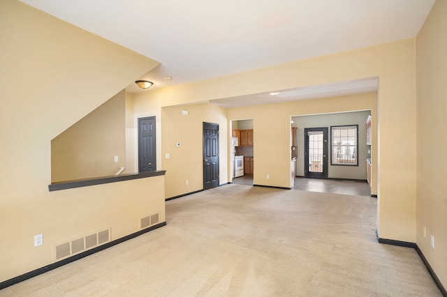 unfurnished room featuring light colored carpet, visible vents, and baseboards