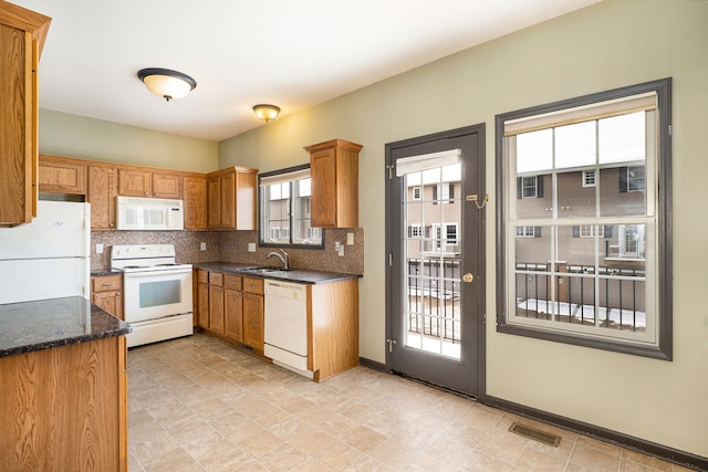 kitchen with white appliances, tasteful backsplash, visible vents, and brown cabinetry