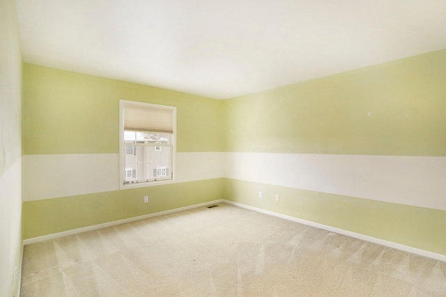 carpeted empty room featuring visible vents and baseboards