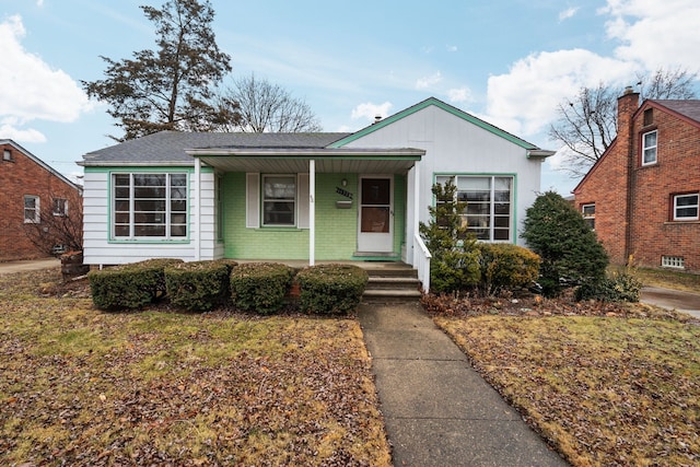 view of front of home with covered porch and brick siding