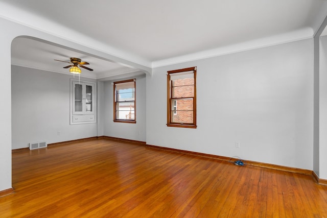 unfurnished room featuring ceiling fan, visible vents, crown molding, and wood finished floors