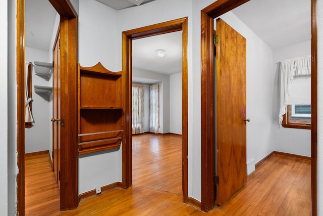 hallway with baseboards and hardwood / wood-style floors