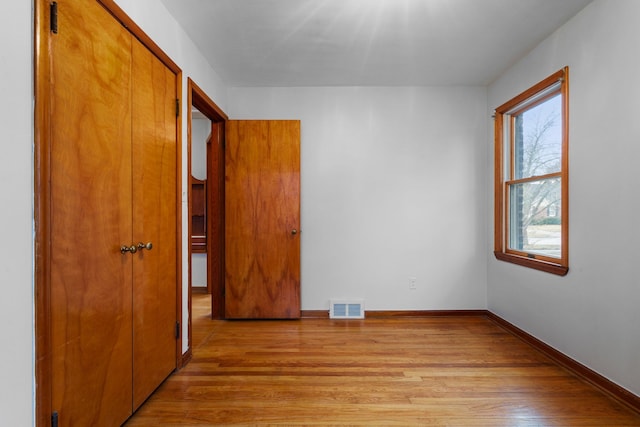 unfurnished bedroom featuring light wood-type flooring, visible vents, and baseboards